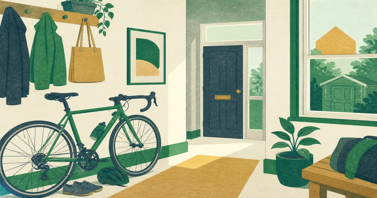 Bicycle stored in a home hallway beside a coat rack